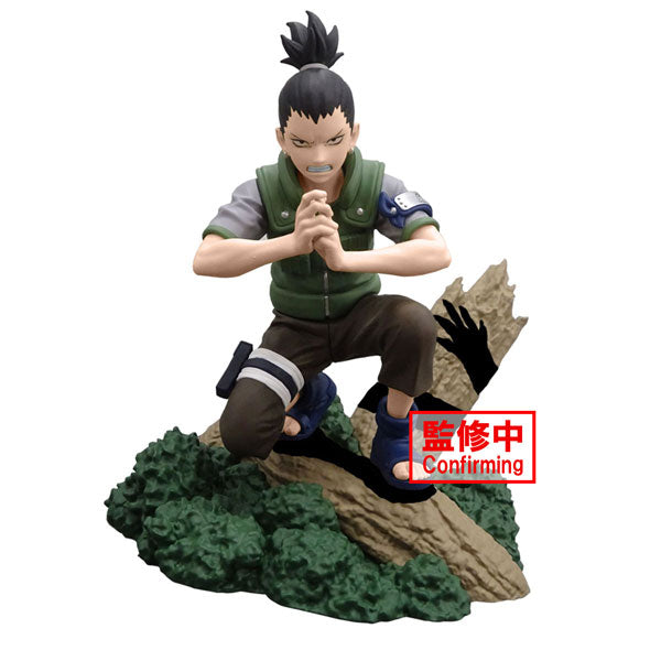 The Bandai Naruto Memorable Saga - Nara Shikamaru figurine features an anime character with dark hair pulled up, dressed in a green vest and blue sandals. The character is posed crouching on a rock formation with hands forming a symbol, and the design includes red text overlay.