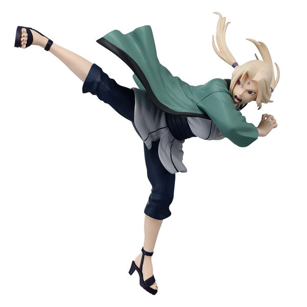 Bandai presents the Naruto Banpresto Figure Colosseum - Tsunade figure, featuring an anime-style depiction of a character mid-kick. She's wearing a green jacket, gray and black attire, and black sandals, with her blonde hair tied back in an action-packed pose against a plain white background.